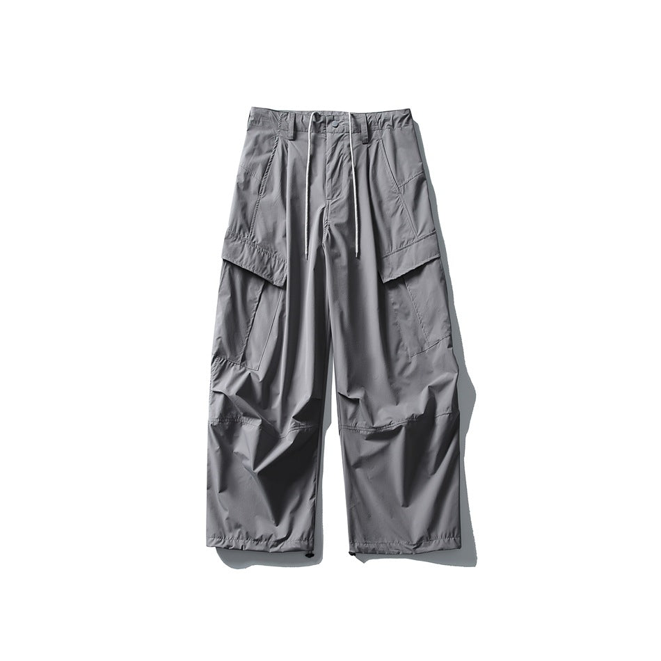 Light gray wide-leg cargo pants flat lay with white drawstring, flap cargo pockets and knee seams