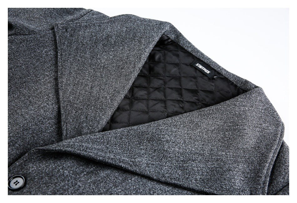 Close-up of a charcoal coat's wide lapel and black diamond-quilted lining, with a sewn-in label.