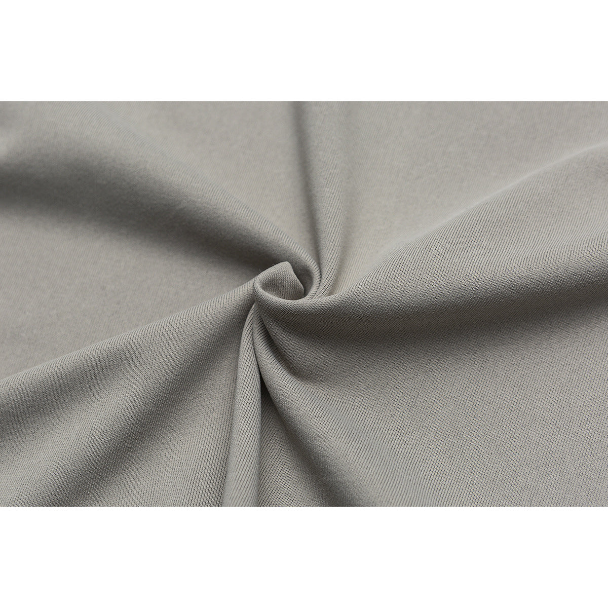 Close-up of gray fabric gathered into folds, showing its surface texture.