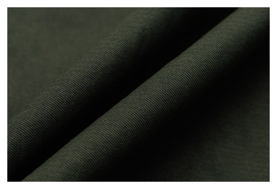 Close-up of dark olive fabric with fine ribbed texture and a diagonal fold.