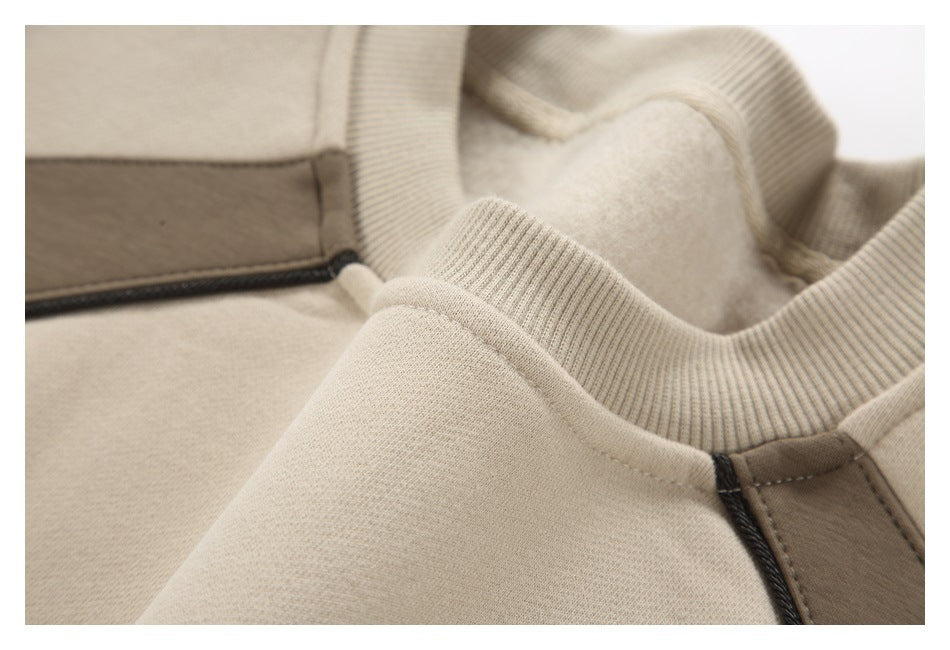 Close-up of the beige sweatshirt's ribbed neckline, brushed inner surface, and taupe panel.