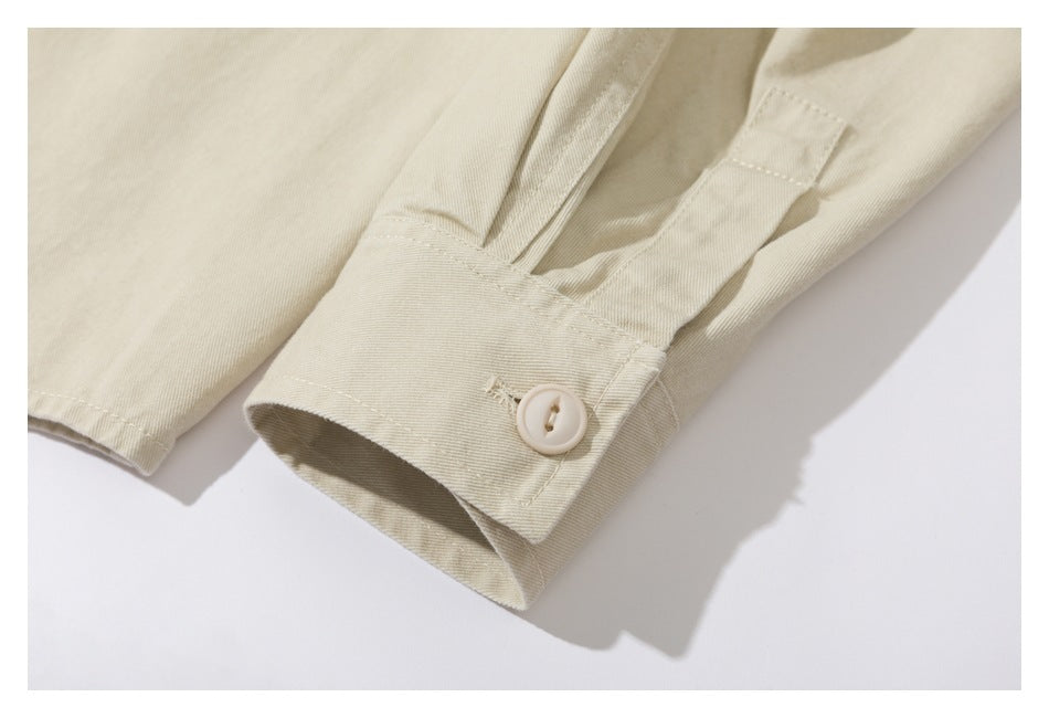Close-up of an ivory sleeve cuff with a cream button and stitched opening.