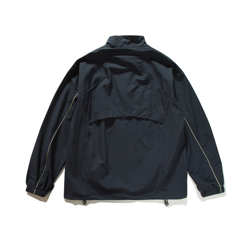 Back view of navy jacket with yoke seam, olive sleeve piping, elastic cuffs and drawcord hem