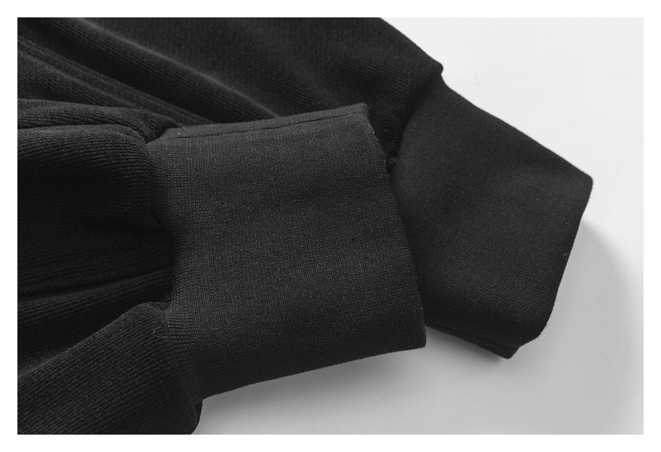 Close-up of a black ribbed knit cuff and adjoining fabric.