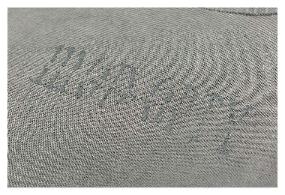 Close-up of faded dark lettering printed diagonally on gray fabric.