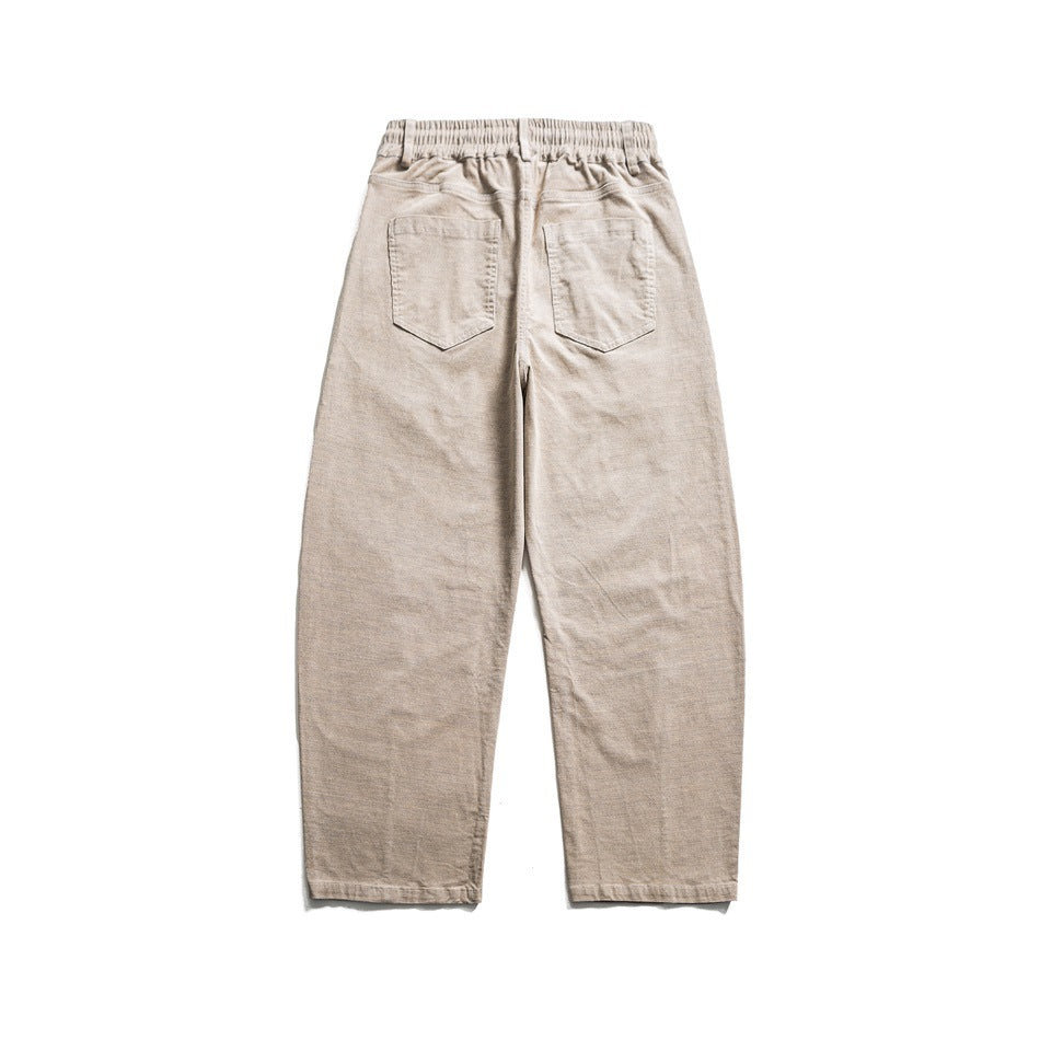 Back view of beige relaxed trousers with an elastic waistband and two patch pockets.