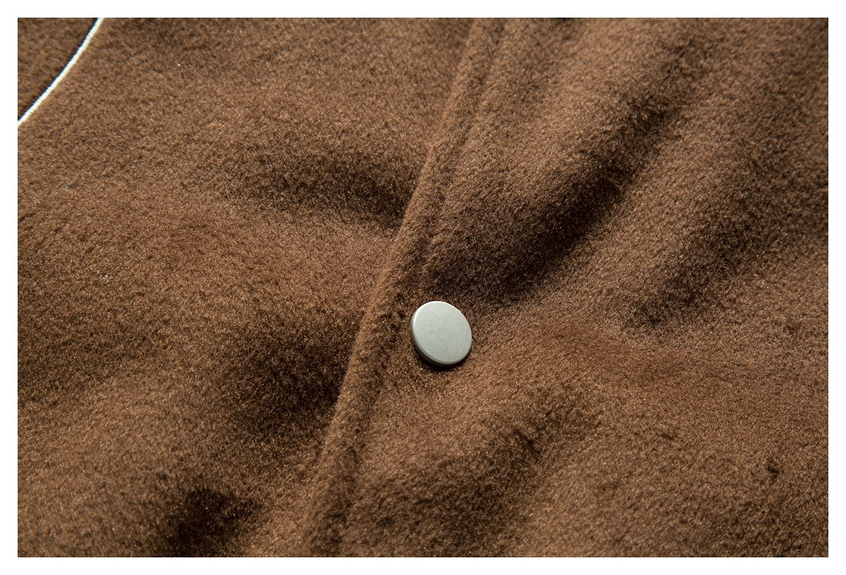 Close-up of a silver snap fastener on the brown fuzzy jacket front.