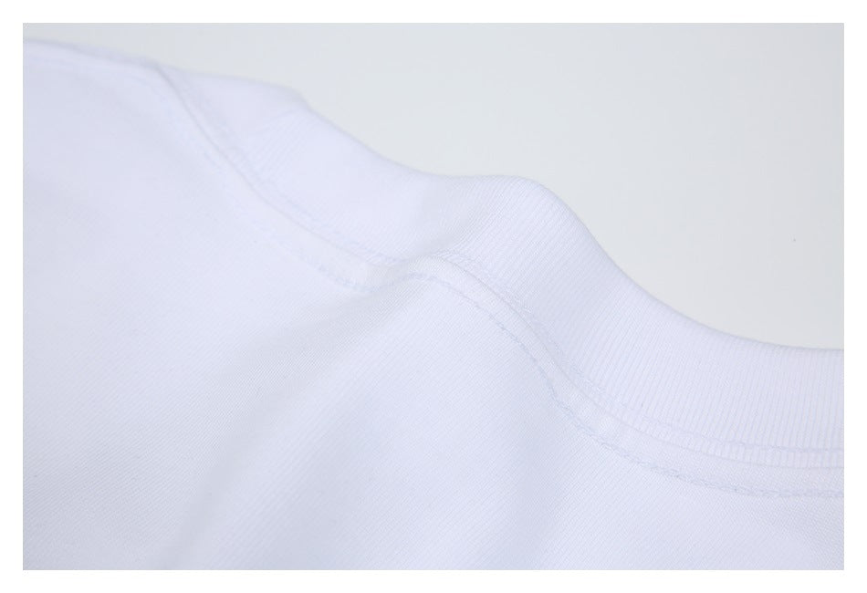 Close-up of the ribbed crew neckline and shoulder seam of a white shirt.
