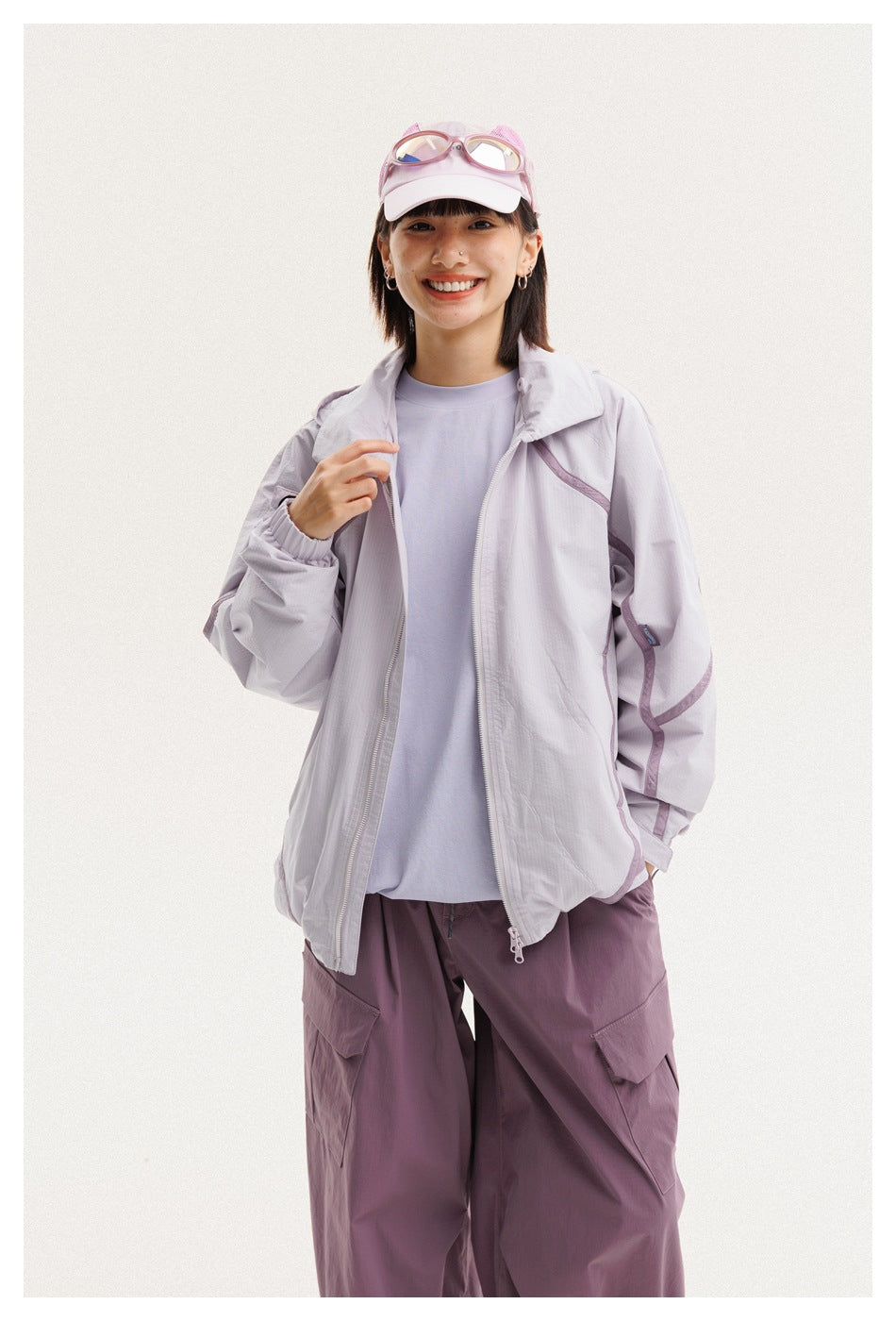 Closer view of a woman in an open light lavender jacket over a pale shirt and plum cargo pants.