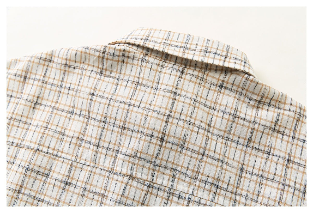Close-up of the back of a cream plaid shirt, showing its collar and horizontal yoke seam.