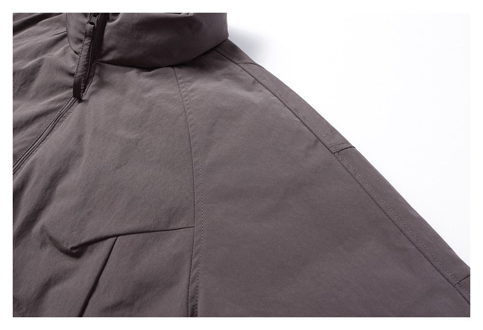Close-up of the jacket’s charcoal fabric and curved shoulder and sleeve seams.