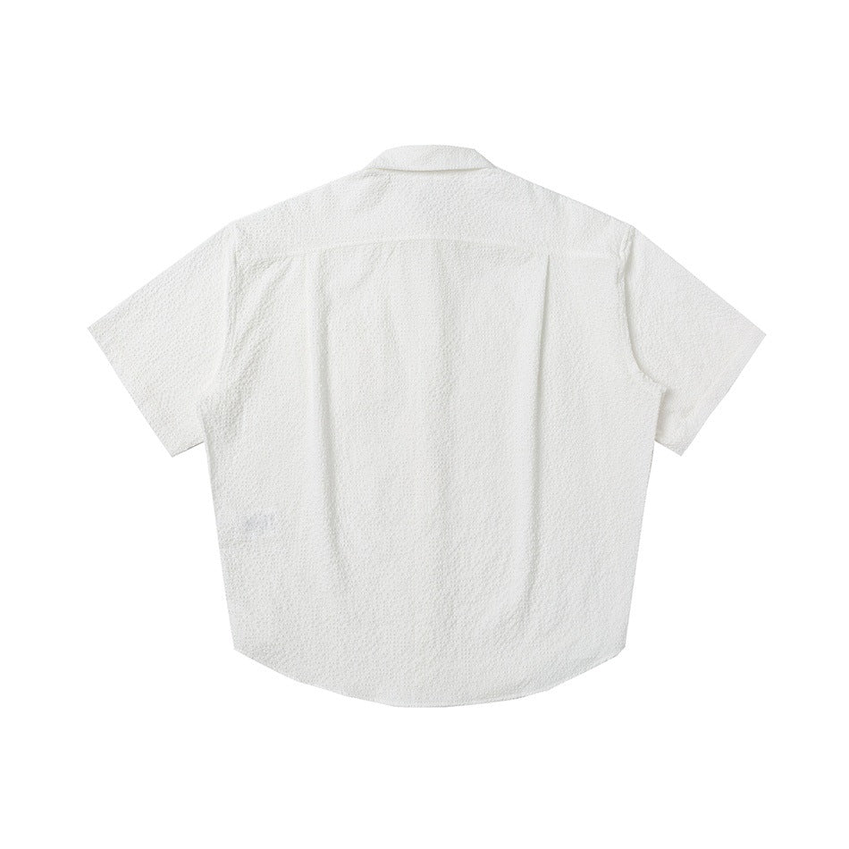 Back view of a white textured short-sleeve button-up shirt.