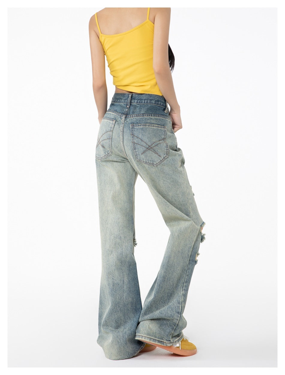 Model wearing faded blue wide-leg jeans with crossed stitching on the back pockets, shown from behind.