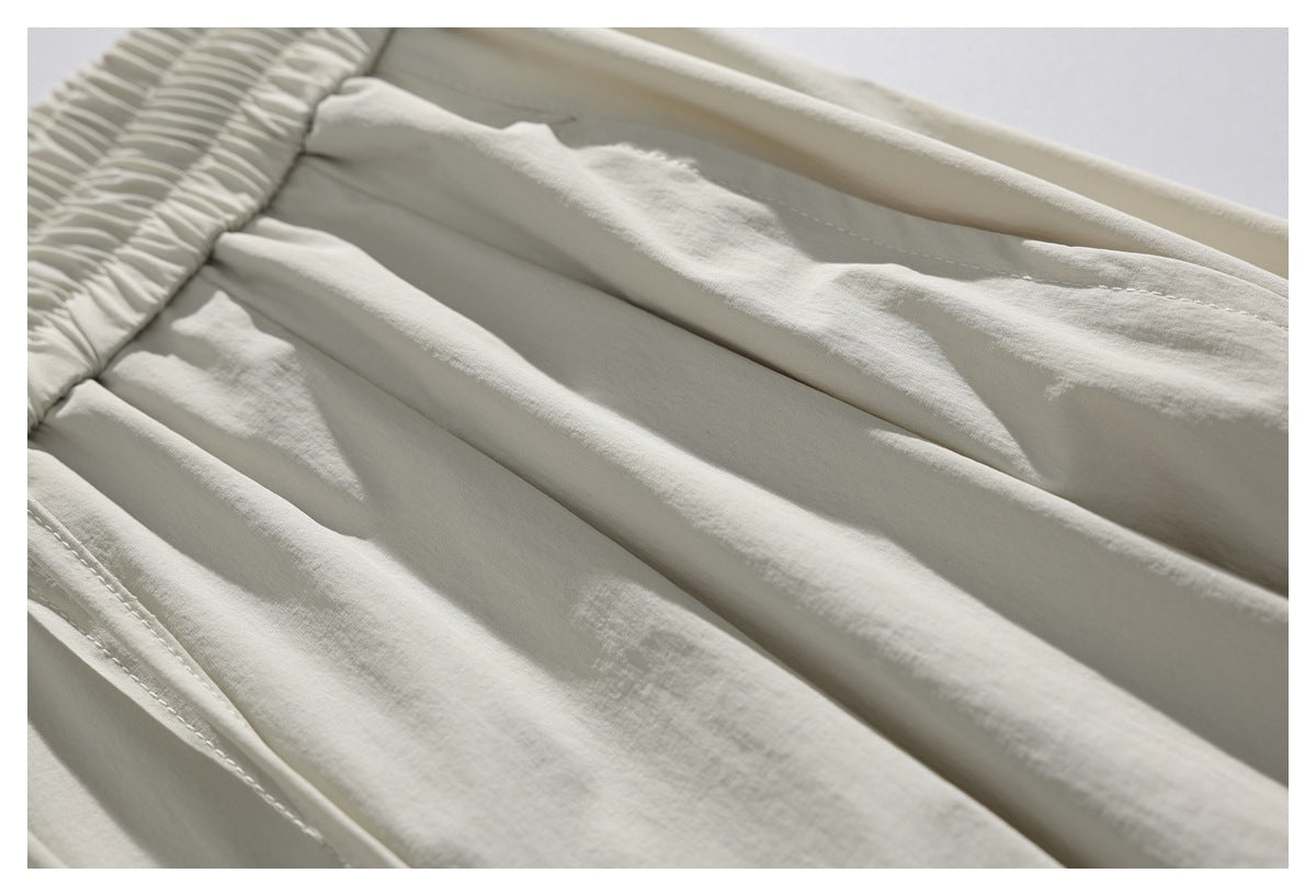 Close-up of the shorts' gathered waistband and fabric pleats in light ivory.