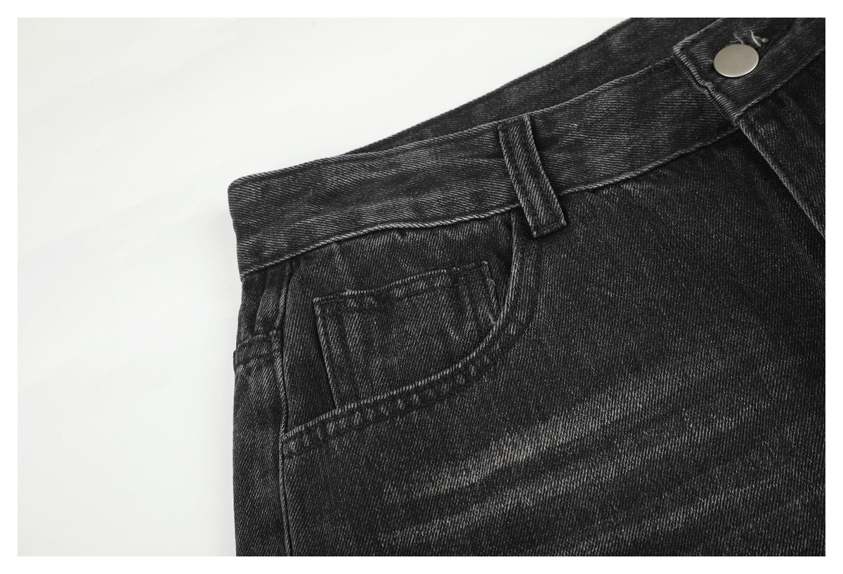 Close-up of charcoal-black jeans showing the front pocket, coin pocket, waistband, belt loop and button.