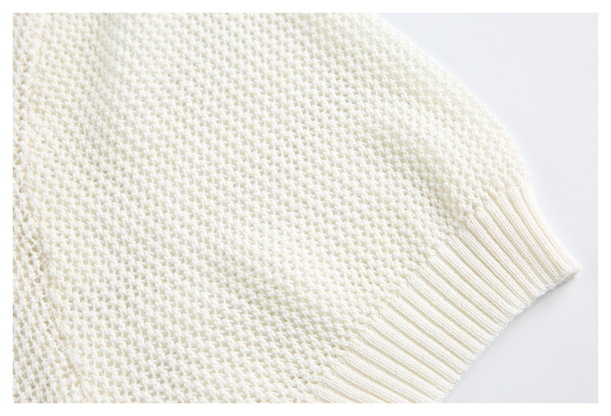 Close-up of the ivory sweater's textured knit and ribbed hem.