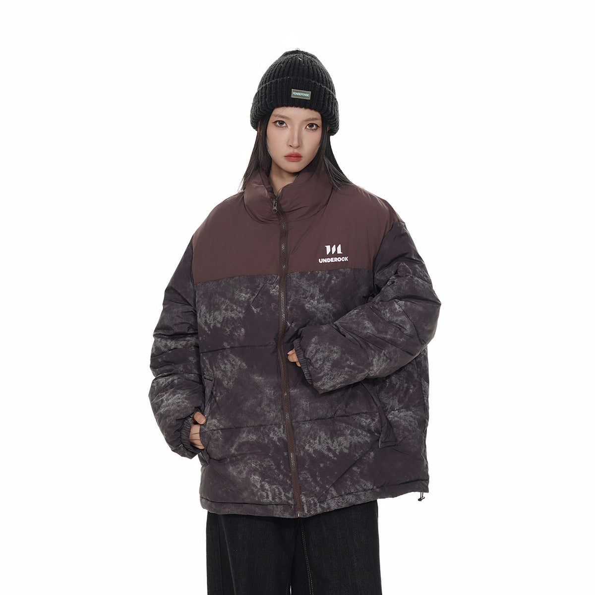 Model wearing a dark charcoal marbled puffer jacket with a muted burgundy yoke and collar.