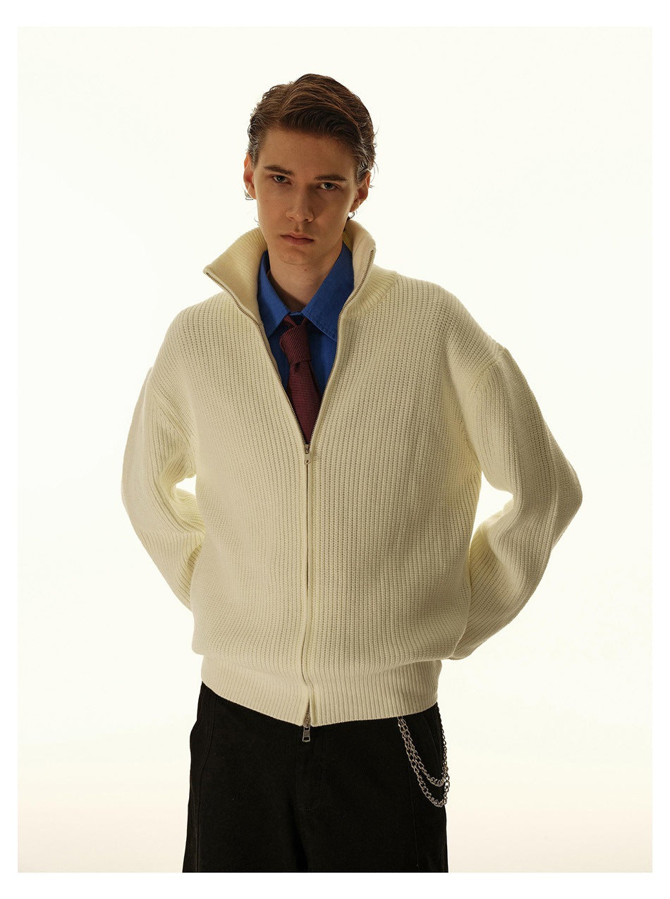 Front view of a model wearing a cream ribbed zip-up cardigan with a blue shirt and burgundy tie.