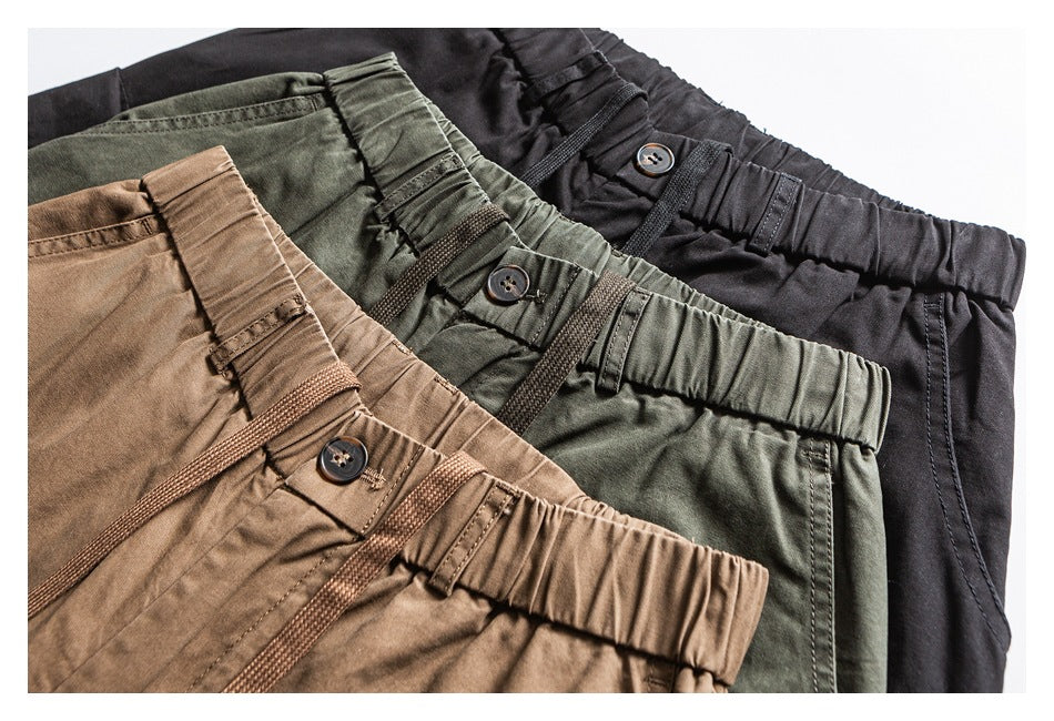 Close-up of three pairs of casual pants in tan, olive green, and black, showing elastic waistbands and drawcords.