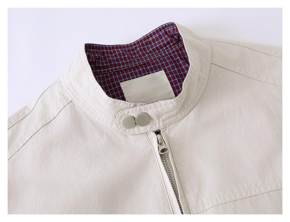 Close-up of the beige jacket's stand collar, metal zipper and two-button closure, with red and navy plaid lining.