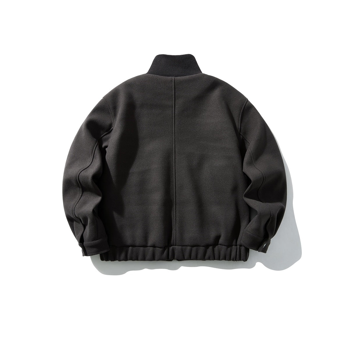 Back view of a dark charcoal zip jacket with a stand collar and gathered hem.