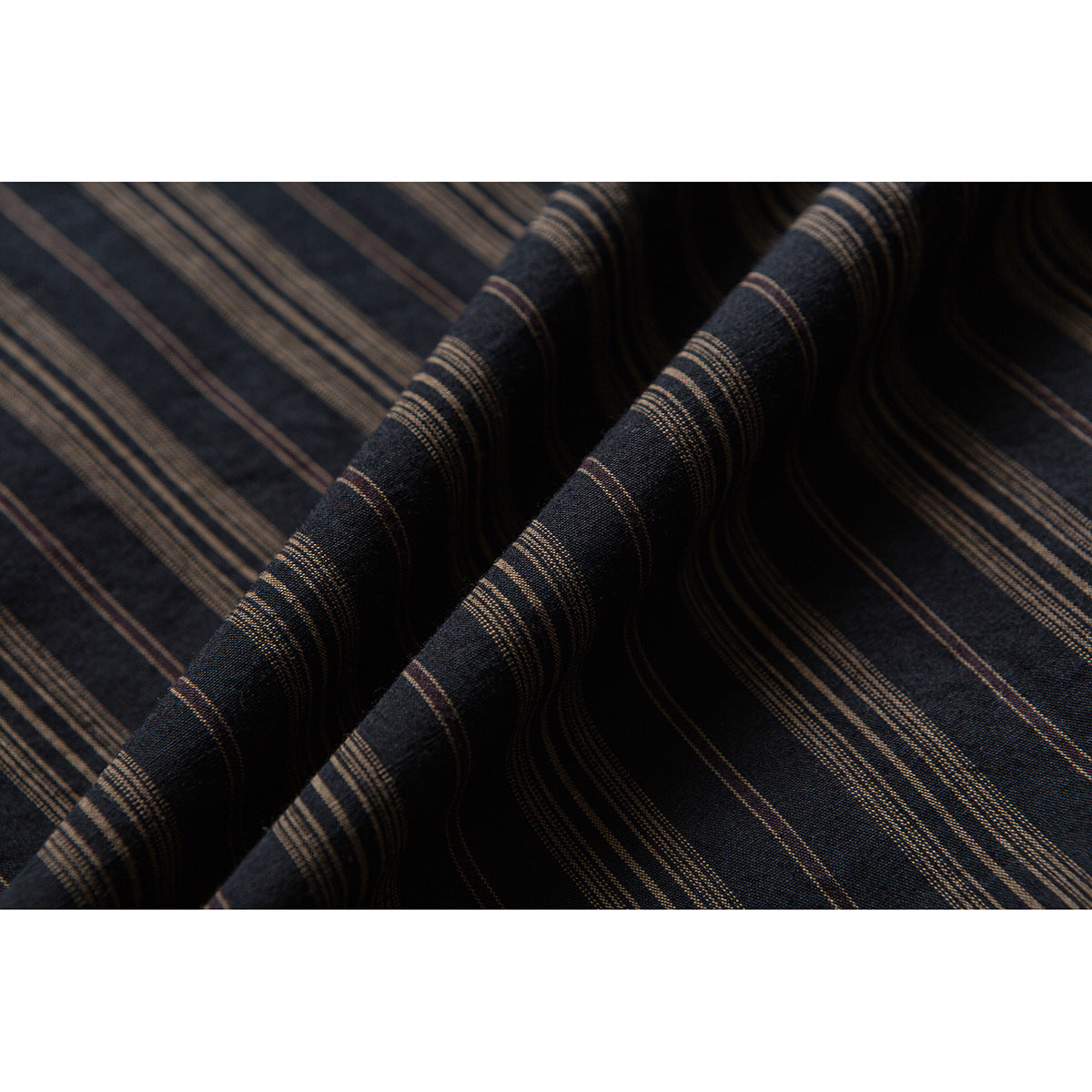 Close-up of dark fabric folds showing fine brown stripe patterns.