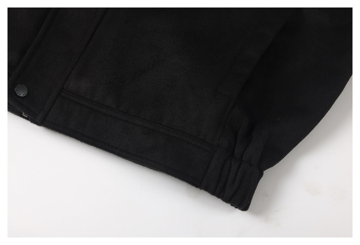 Close-up of the black jacket's lower front, showing a welt pocket, hem, and sleeve cuff.