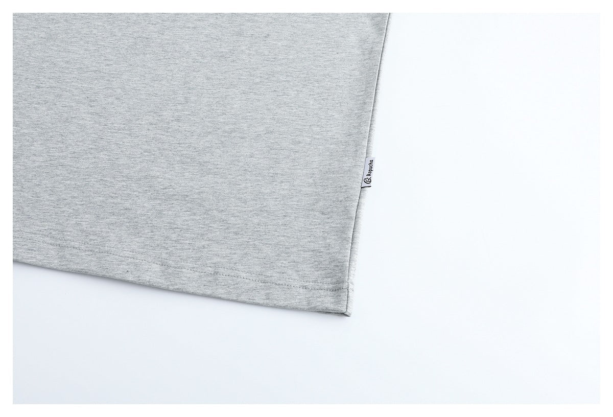 Close-up of the light gray T-shirt hem with a small side label.