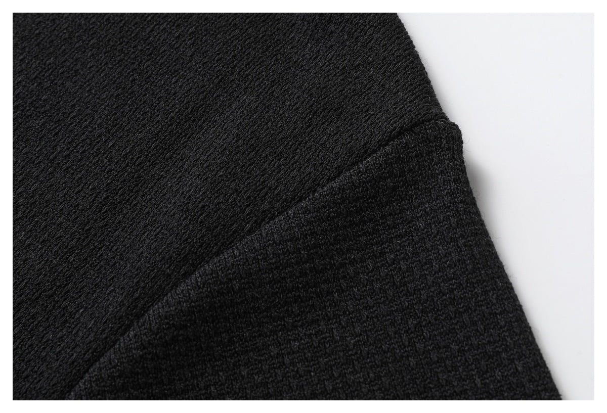 Close-up of the black shirt's sleeve seam and textured fabric.