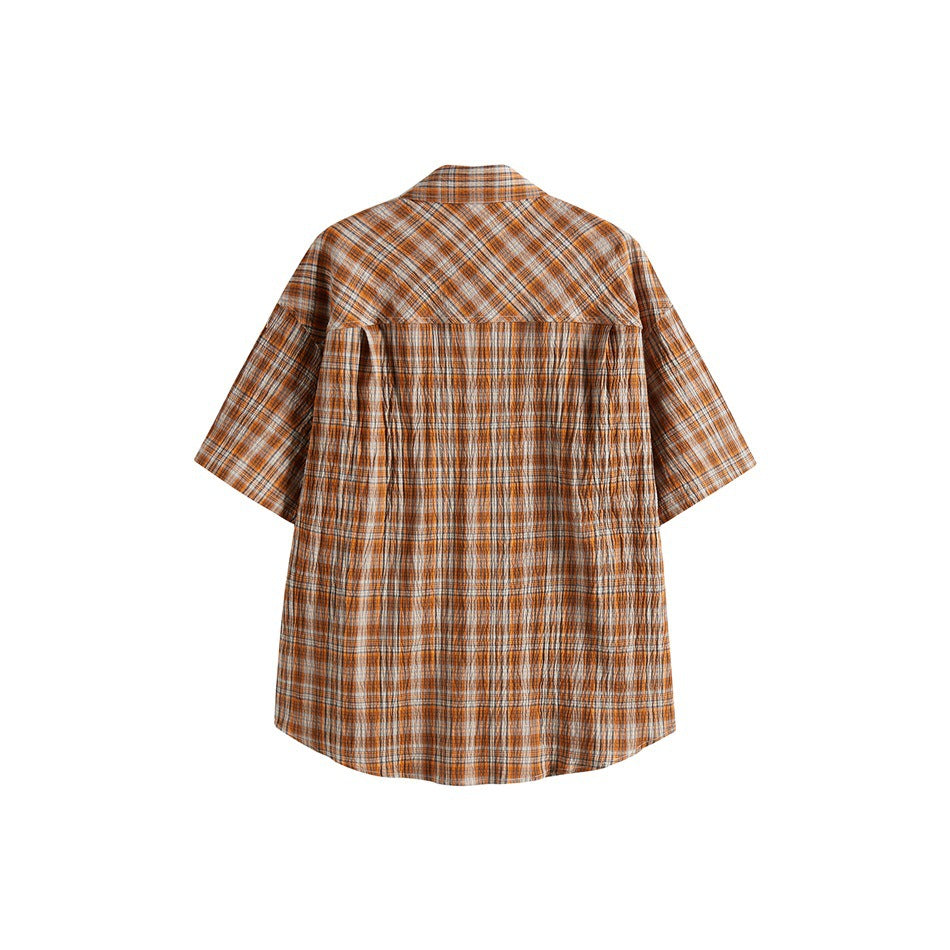 Back view of an orange plaid short-sleeve shirt showing the diagonal plaid yoke and curved hem