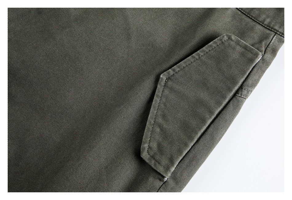 Close-up of a flap cargo pocket and stitching on olive pants.