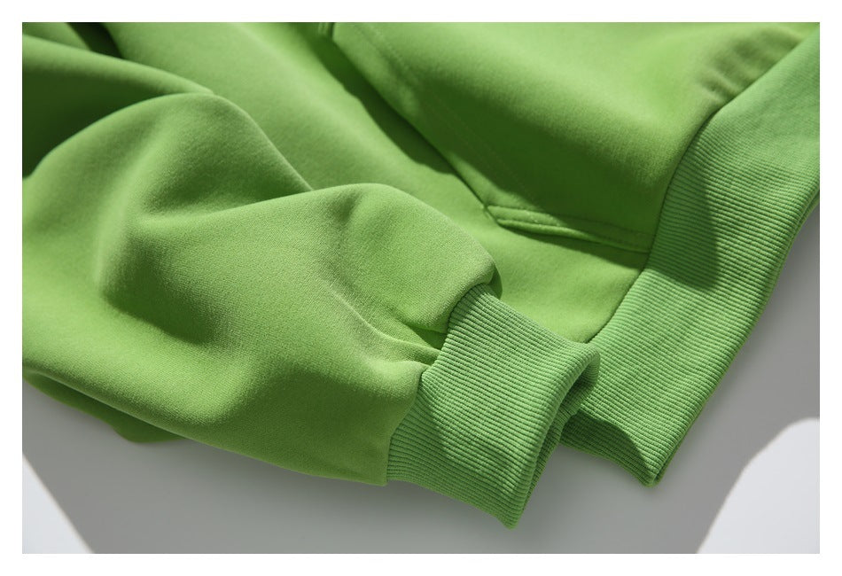 Close-up of the green pullover's gathered sleeve and ribbed cuff beside the ribbed hem.