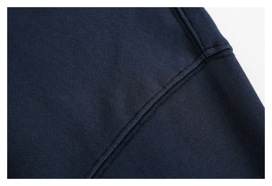 Close-up of a stitched seam joining the navy sweatshirt body and sleeve.