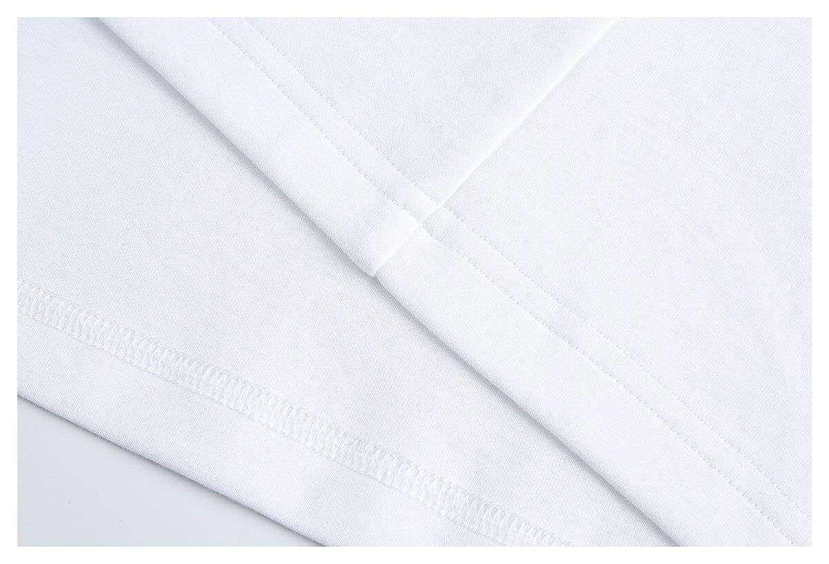 Close-up of the white T-shirt's folded hem and interior overlock stitching.