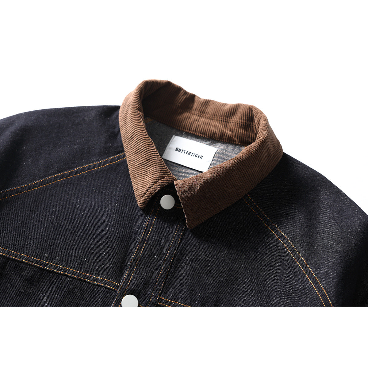 Close-up of a dark denim jacket with a brown ribbed collar, white snap, and orange contrast stitching.