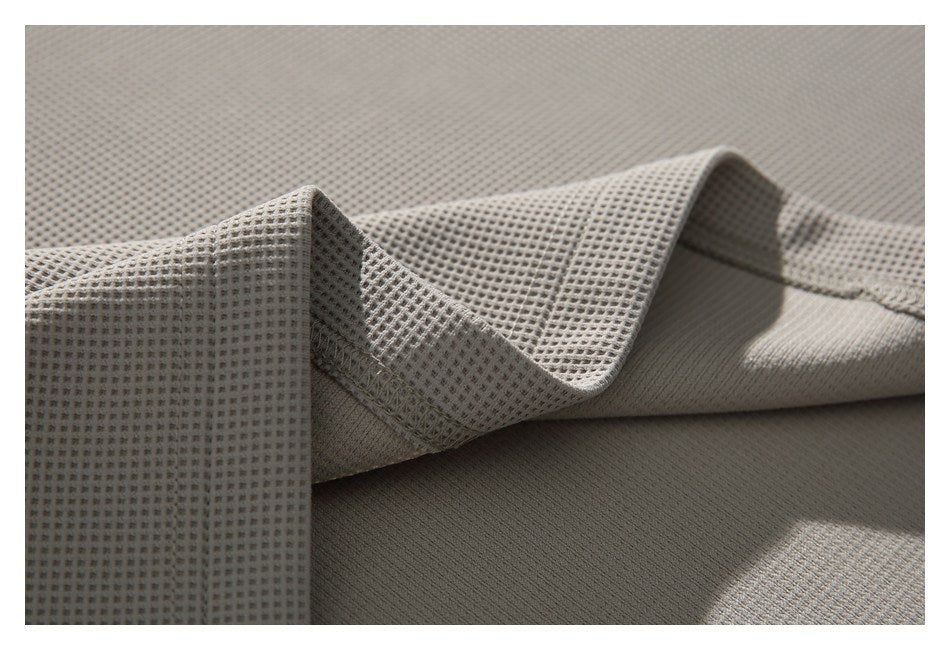 Close-up of taupe waffle-knit fabric folded to show a stitched seam and ribbed edge.