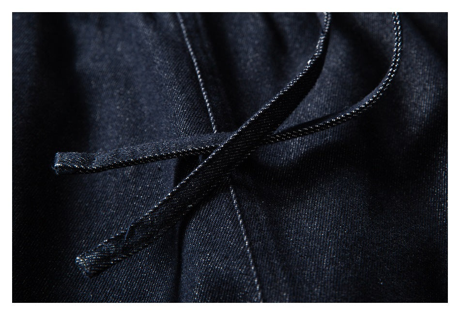 Close-up of dark indigo pants with matching drawstrings crossing over the fabric.
