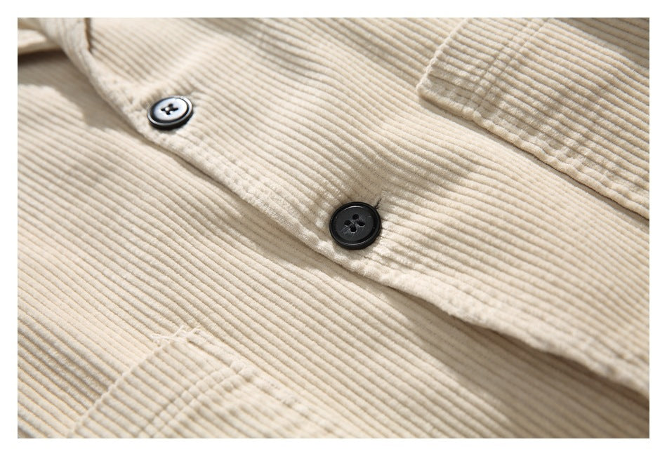 Close-up of the cream jacket's front placket with dark buttons and a patch pocket edge.
