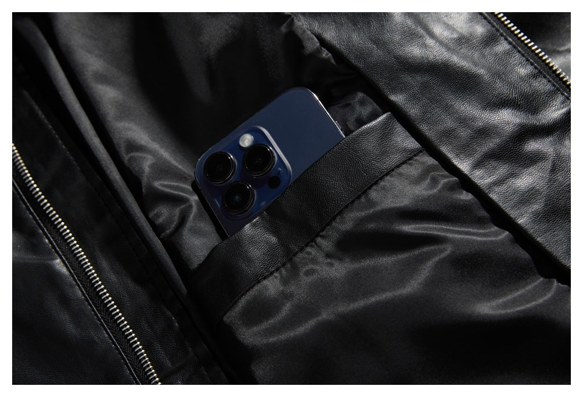 A phone peeks from an inner pocket of the open black jacket, beside its zipper.