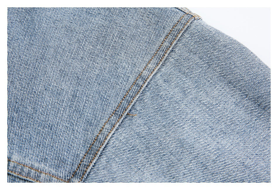 Close-up of light blue denim with a diagonal double-stitched seam.