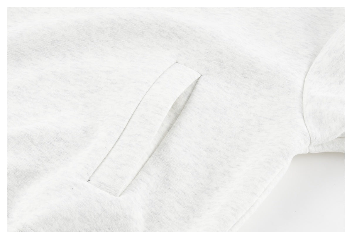 Close-up of a slanted welt pocket on a light gray sweatshirt.