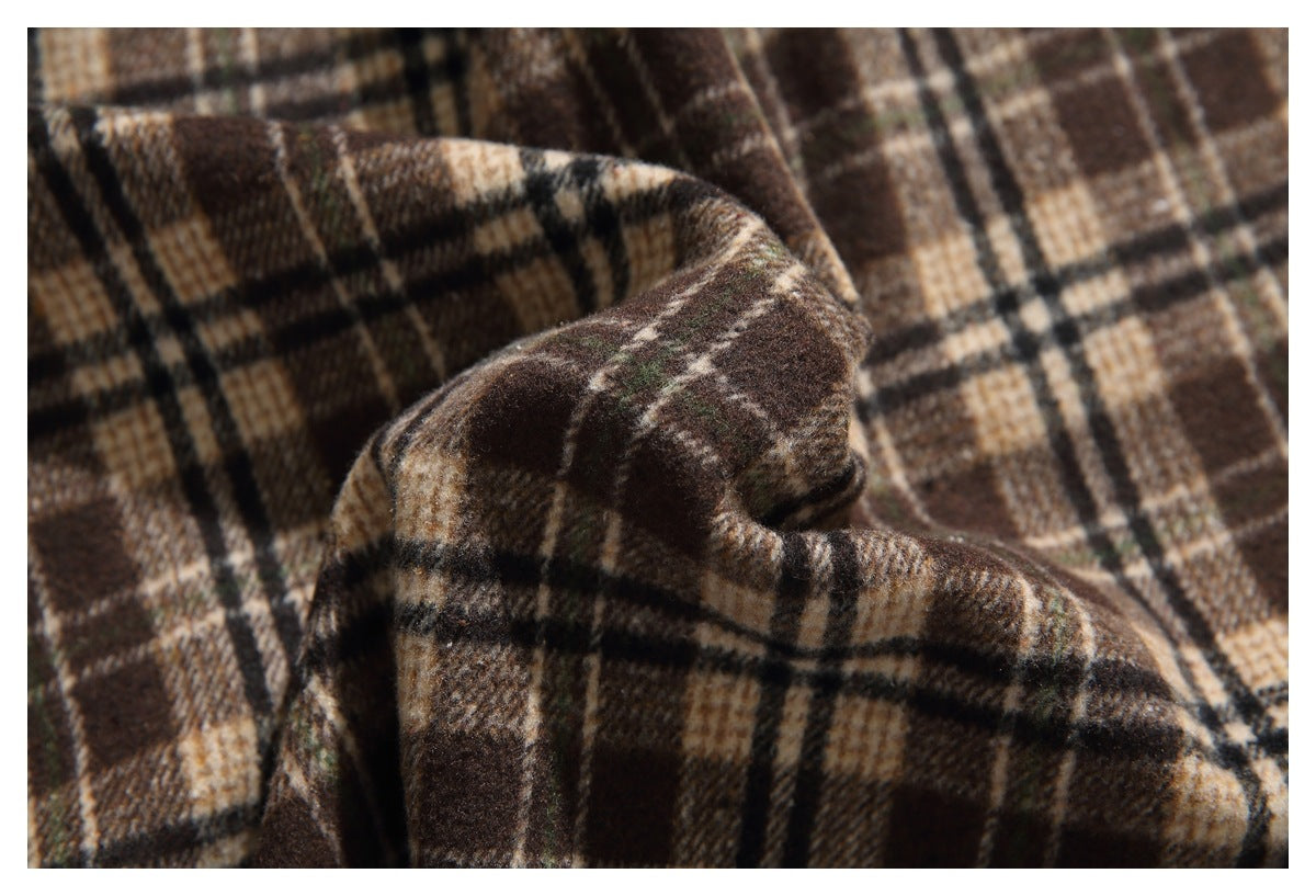 Close-up of the soft-looking brown and tan plaid fabric folded to show its pattern and texture.