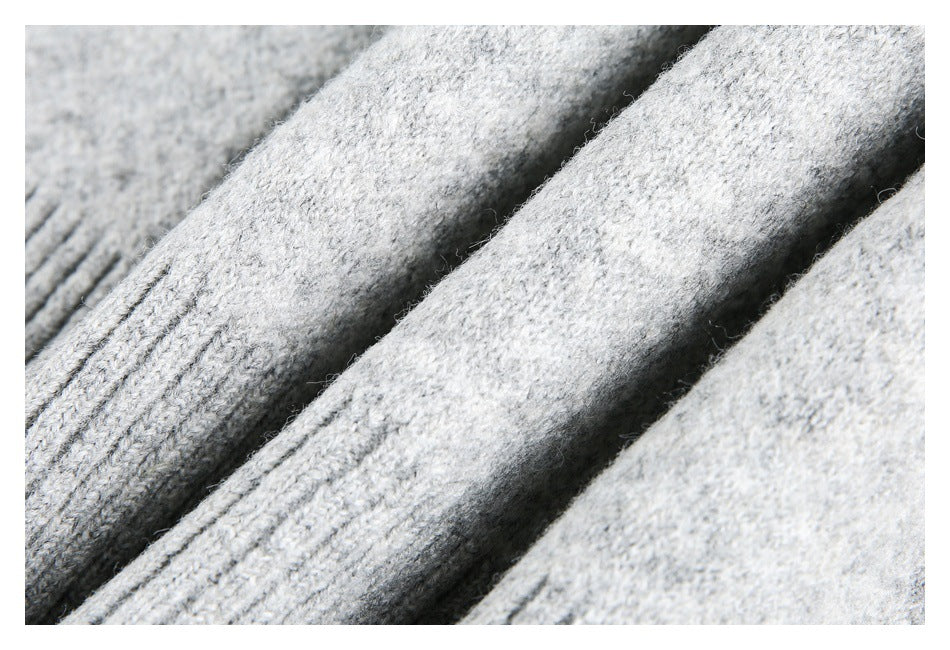 Macro view of soft-looking light gray knit fabric arranged in folds.