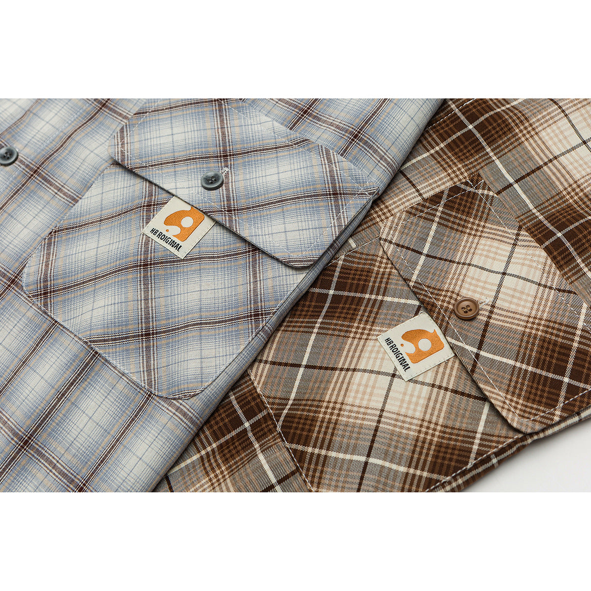 Close-up of blue-gray and brown plaid shirts, showing collars, buttons and chest pockets.