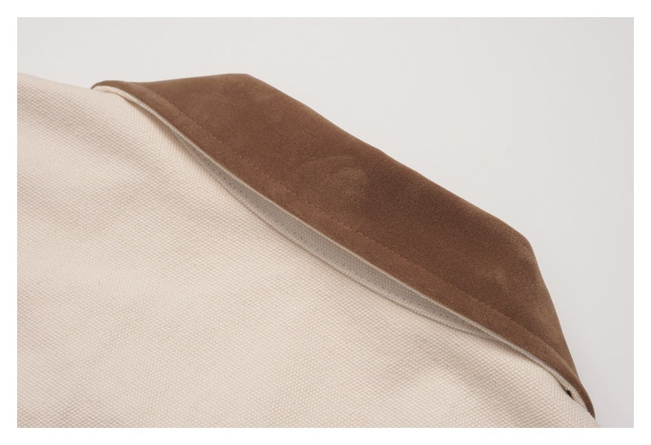 Close-up of a cream textured coat with a contrasting brown collar.