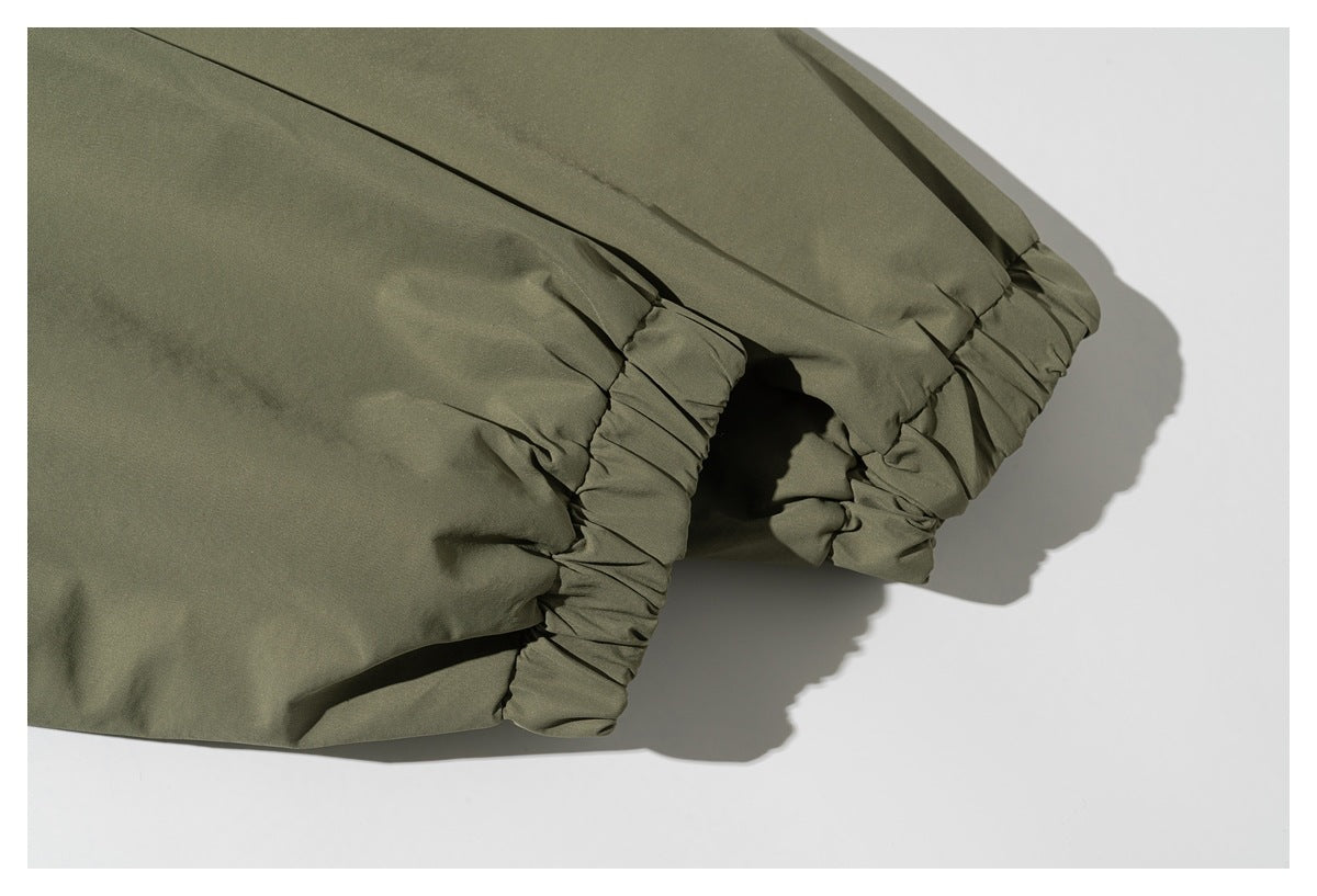 Close-up of an olive-green garment with a gathered elastic edge and ruched fabric.
