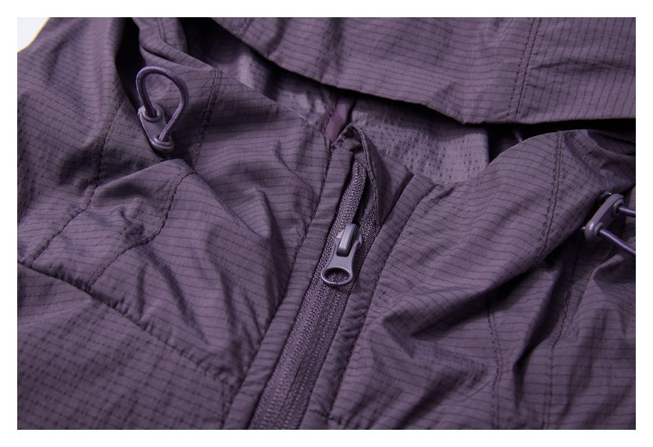 Close-up of a dark purple jacket neckline with a front zipper and drawcord toggles.