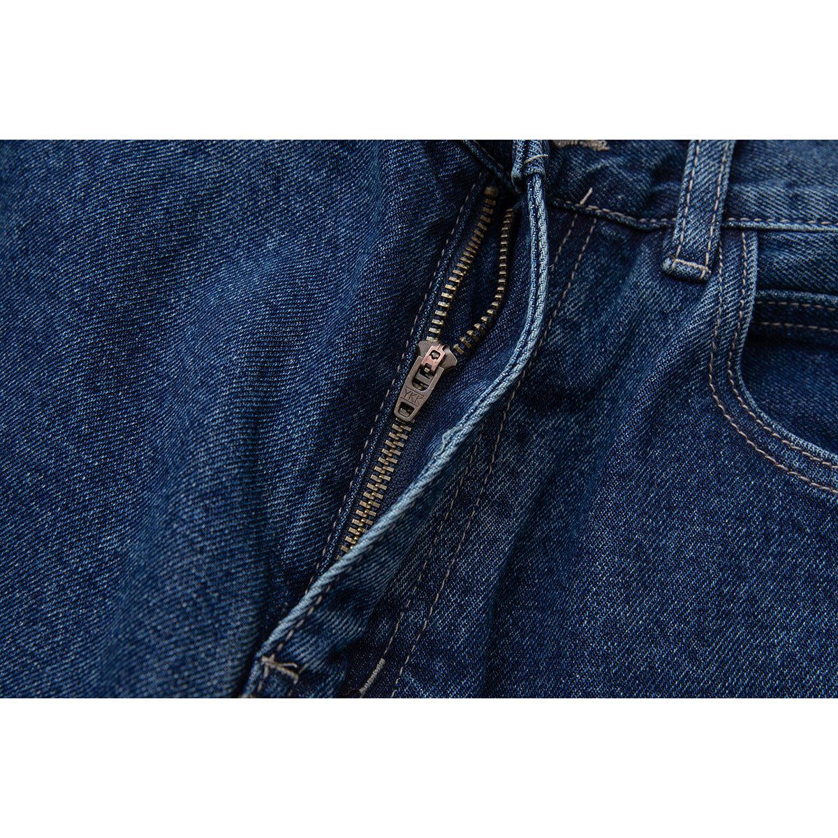 Close-up of dark blue jeans with the metal fly zipper open.
