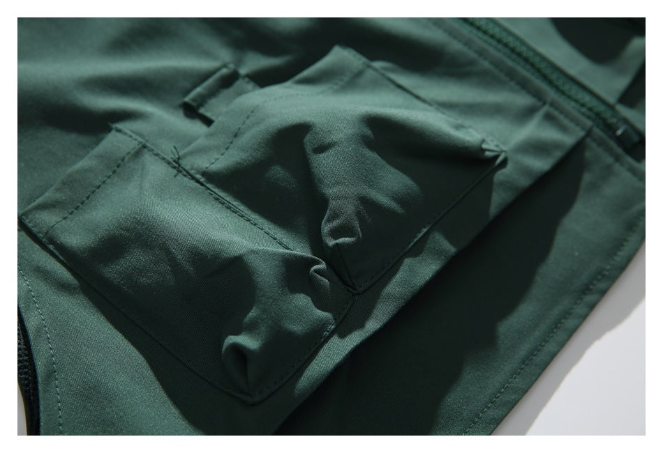 Close-up of two dark green cargo-style pockets with folded fabric flaps.