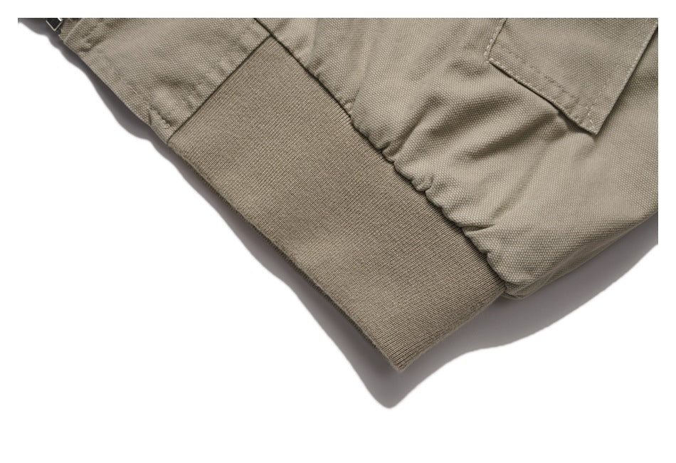 Close-up of the jacket’s gathered lower edge, pocket corner, and ribbed hem.